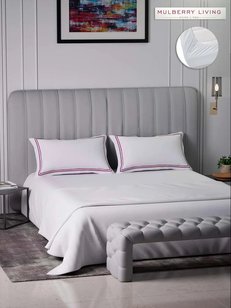 Gray upholstered bed with sovereign white bedding with double Mulberry color marrowing in a bedroom setting